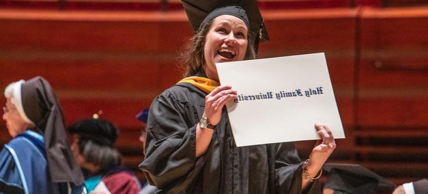 Woman holding diploma case at commencement